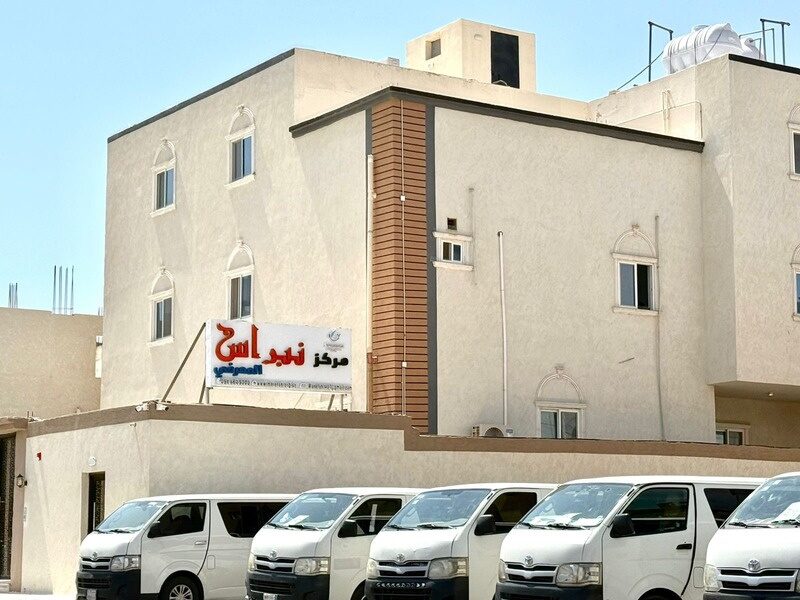 مبنى مركز نبراس المعرفي في المدينة المنورة وأمامه أسطول حافلات النقل