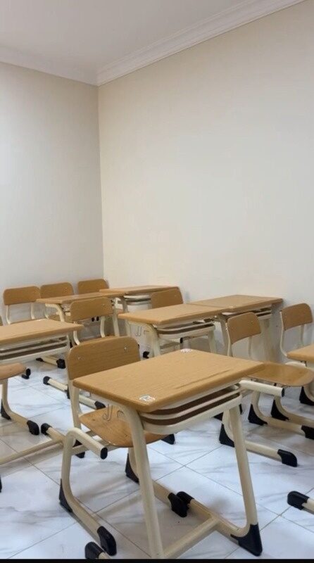 قاعة دراسية بمقاعد خشبية في أحد مراكز الأكاديمية